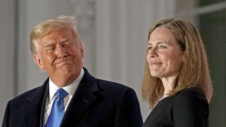 President Donald Trump and Justice Amy Coney Barrett stand on a balcony during a ceremony on the South Lawn of the White House in Washington, D.C., on Monday, Oct. 26, 2020. (Ken Cedeno/CNP/Bloomberg via Getty Images)