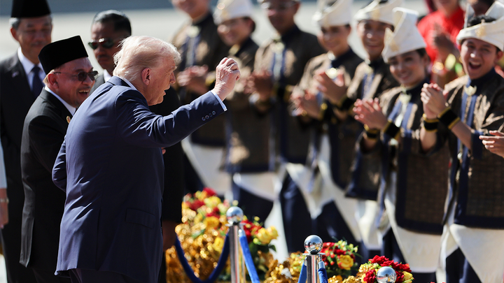 President Donald Trump reacts to dancing performers during a welcoming ceremony after arriving at Kuala Lumpur International Airport. (AP)
