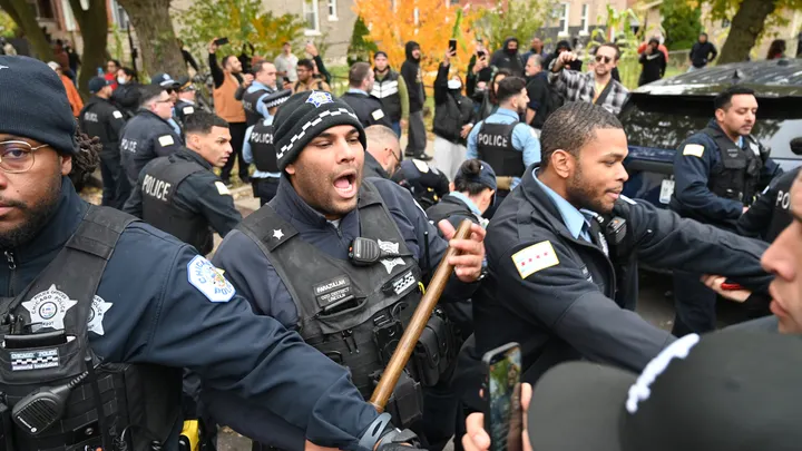 Police officers take security measures with batons as U.S. Immigration and Customs Enforcement (ICE) agents conduct operations in the Little Village neighborhood, a predominantly Mexican-American community, on Nov. 8, 2025 in Chicago, Illinois.  (Jacek Boczarski/Anadolu via Getty Images)