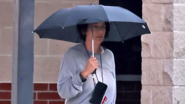 Ghislaine Maxwell holds her umbrella high enough over her head to expose her face. Maxwell left for her prison job before sunrise and was still walking with an umbrella covering her face. During her lunch break, she walked back to her cell carrying some folders and a clear backpack with headphones dangling down Sept. 20, 2025. (Matthew Symons/Mirrorpix/Mega)