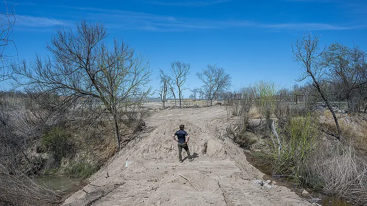 Community resident and farmer Byer Junfin, 37, surveys land and water flow near a Flow Meter Station on February 22, 2023, in Quemado, Texas. (Brandon Bell/Getty Images)
