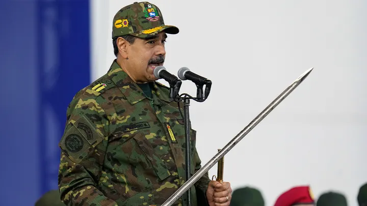 Venezuelan President Nicolas Maduro holds a ceremonial sword said to have belonged to independence hero Simon Bolivar during a government-organized civic-military march in Caracas, Venezuela, Tuesday, Nov. 25, 2025. (Ariana Cubillos/AP Photo)