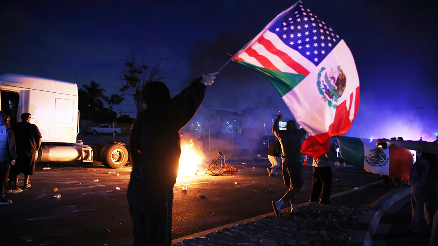 A demonstrator waves an American and Mexican flag during a protest in Compton, California, June 7, 2025, after federal immigration authorities conducted operations. (Ethan Swope/The Associated Press)