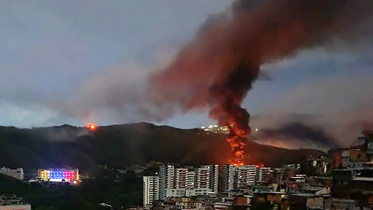 Fire at Fuerte Tiuna, Venezuela's largest military complex, is seen from a distance after a series of explosions in Caracas on Jan. 3, 2026. (AFP via Getty Images)