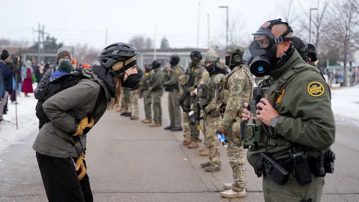 A demonstrator faces a Border Patrol agent during a protest outside the Whipple Building in Minneapolis Thursday. (Tim Evans/Reuters)