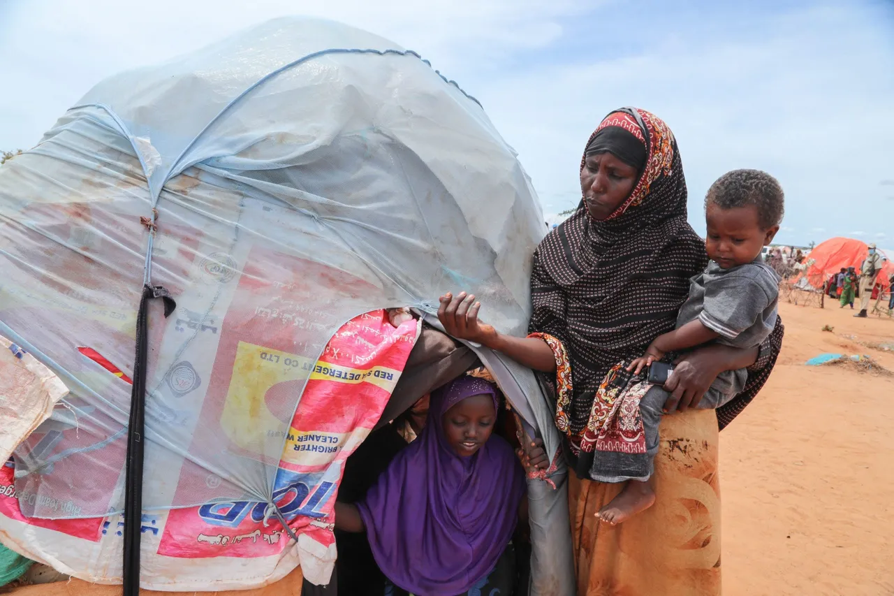 People displaced by drought stand next to their makeshift structure as Cindy McCain (not seen), World Food Programme (WFP) Executive Director, visits to assess drought conditions at the Ladan internally displaced people (IDP) camp in Dolow on May 1, 2023. (Photo by HASSAN ALI ELMI/AFP via Getty Images)