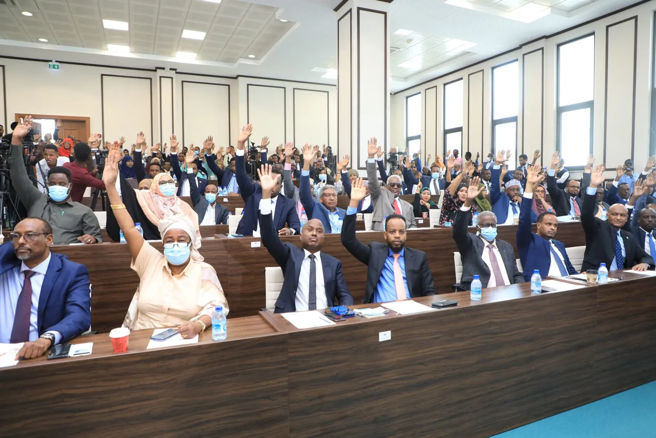 Somali MPs raise their hands during the election of the new Prime Minister in Mogadishu on June 25, 2022. (Photo by HASAN ALI ELMI/AFP via Getty Images)