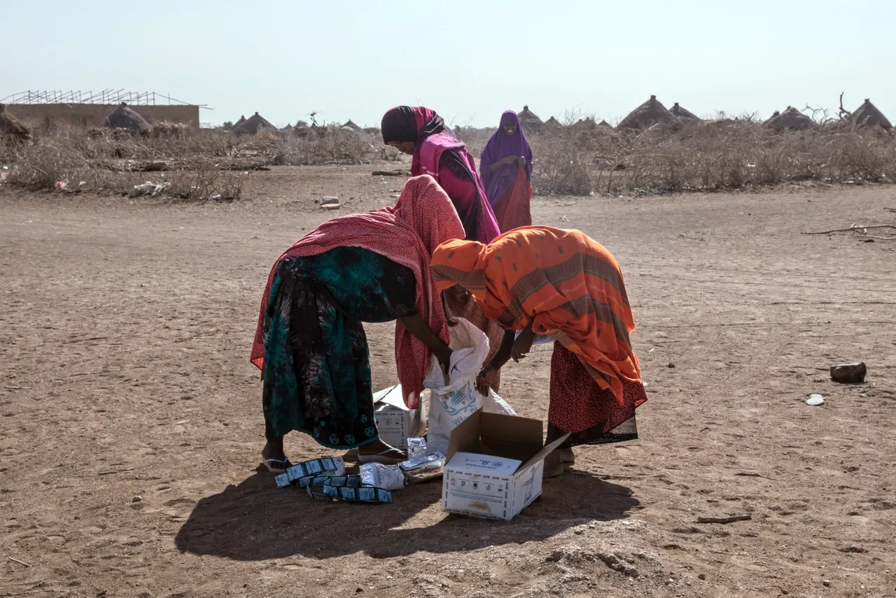Women collect supplies brought by the World Food Programm distribution at the Internally displaced person camp (IDP) of Farburo in Gode, near Kebri Dahar, southeastern Ethiopia, on January 27, 2018. (Photo credit YONAS TADESSE/AFP via Getty Images)