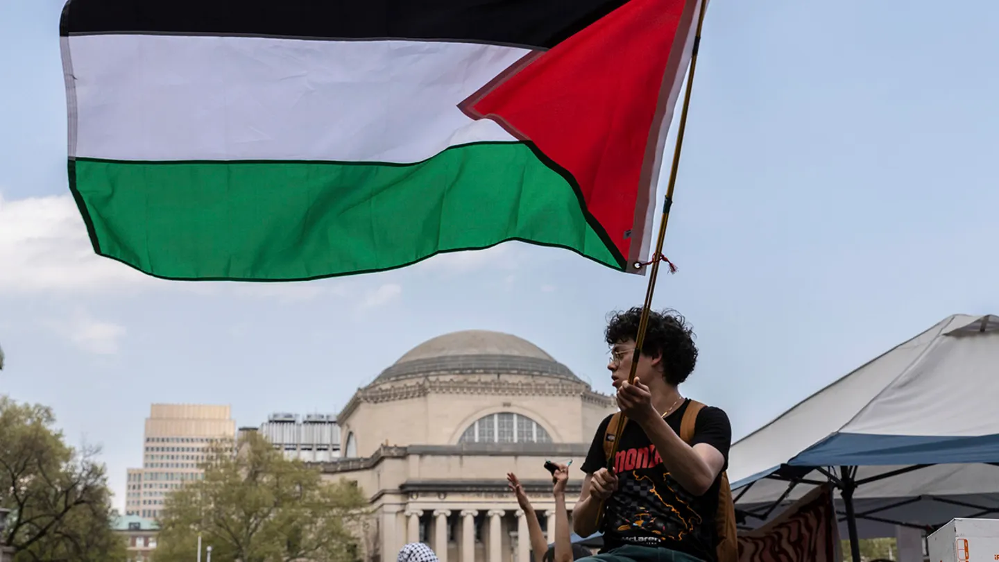 A student protester waves a large Palestinian flag at their encampment on the Columbia University campus, April 29, 2024, in New York. (Stefan Jeremiah/AP Photo)