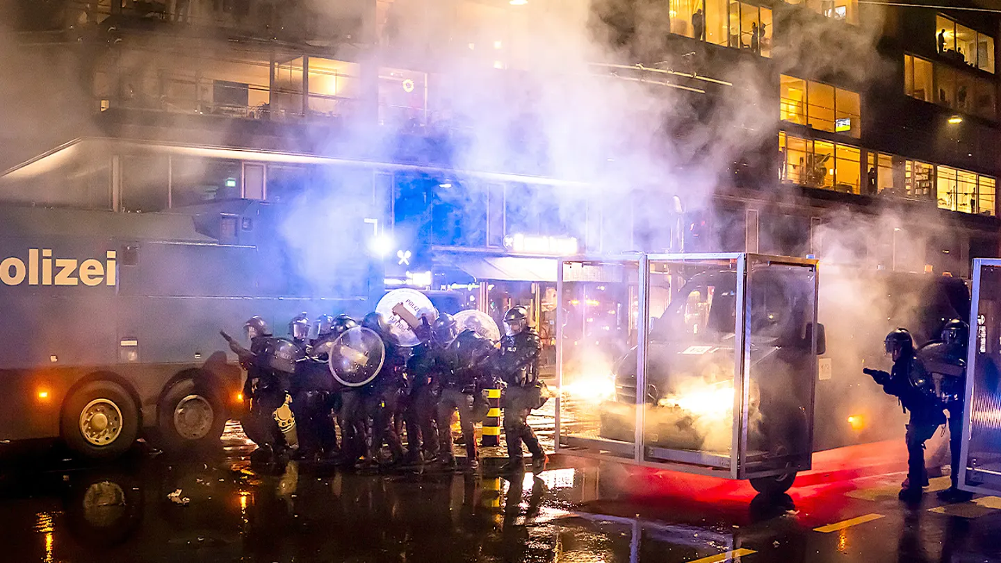 The protests turned violent as demonstrators burn American flags and clash with riot police ahead of President Trump's Wednesday arrival in Switzerland. (Michael Buholzer/Keystone via AP)