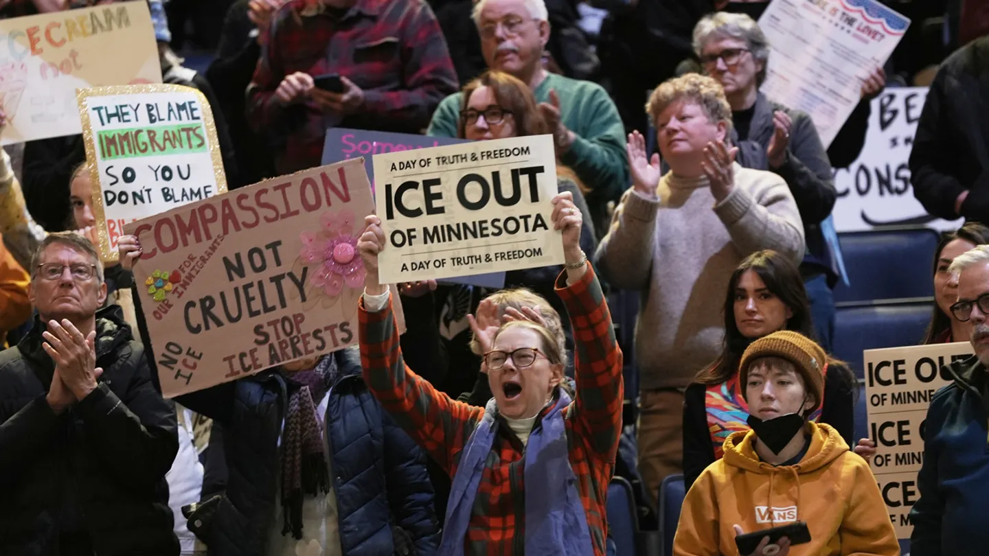 Attendees hold signs during a rally against federal immigration enforcement at Target Center Friday in Minneapolis. (AP Photo/Angelina Katsanis)