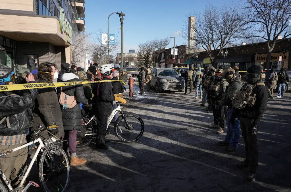 People gather behind cordon tape at the scene of a shooting involving federal immigration agents in Minneapolis, on January 24, 2026. REUTERS