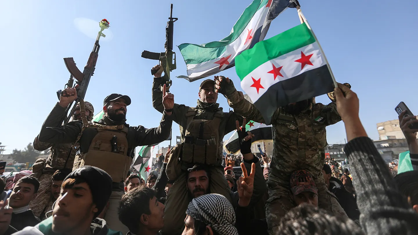 Syrian citizens celebrate and raise Syrian flags on Jan. 20, 2026 in Raqqa, Syria. (Ahmad Hasaballah/Getty Images)