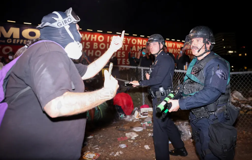 A demonstrator confronts Los Angeles Police Department officers. REUTERS