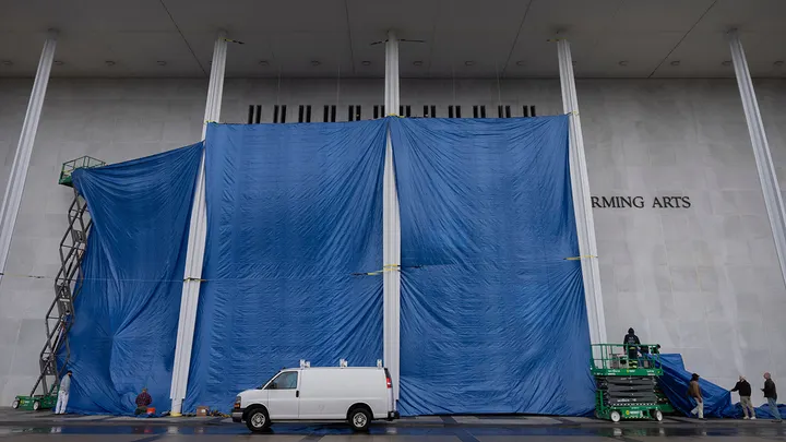 Tarps are installed in front of the sign on the Kennedy Center on Friday, Dec. 19, 2025, in Washington. (Mark Schiefelbein/AP Photo)
