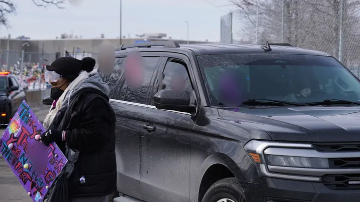 Anti-ICE agitators throw lewd objects at a law enforcement vehicle as it drives by the Bishop Henry Whipple Federal Building on Saturday, in Minneapolis.  (AP Photo/Ryan Murphy)