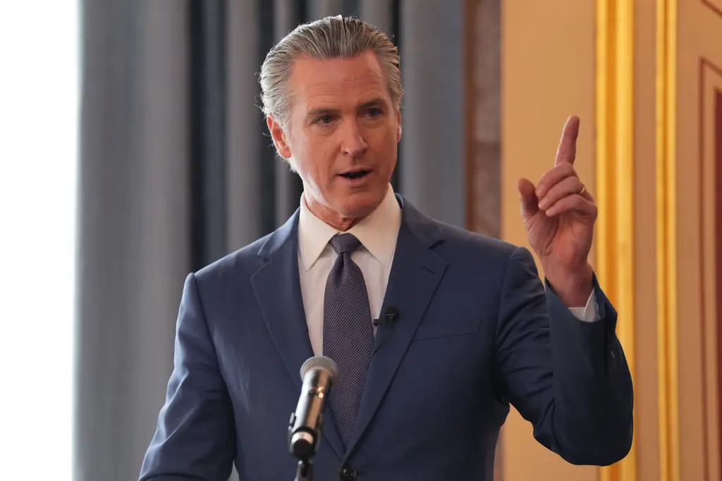 California Governor Gavin Newsom speaking at an event, gesturing with his right hand. AP