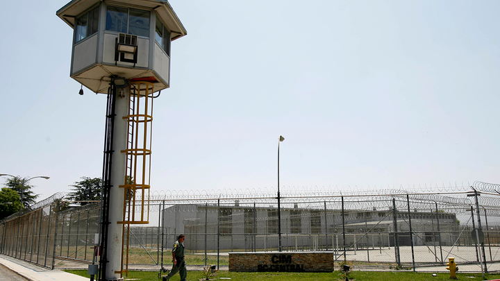 A guard walks outside the California Institution for Men in Chino, a state prison facility. (Ann Johansson/Corbis via Getty Images)