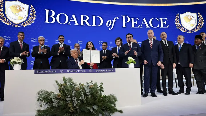Kosovo President Vjosa Osmani, to the right of President Donald Trump, takes part in a charter announcement for his Board of Peace initiative aimed at resolving global conflicts, in Davos, Switzerland, Jan. 22, 2026. (Jonathan Ernst/Reuters)