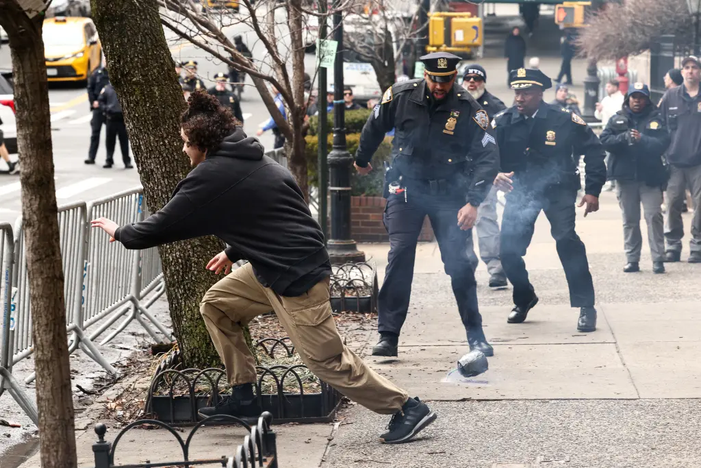 A suspect flees after throwing a homemade explosive device towards police during a protest in New York. 5 Balat tries to flee after throwing a homemade explosive device during an anti-Muslim protest on Saturday. AFP via Getty Images