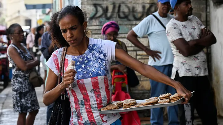 A woman wearing a T-shirt with the United States flag sells Coquito in a street in Havana March 13, 2026.  (Yamil Lage/AFP via Getty Images)