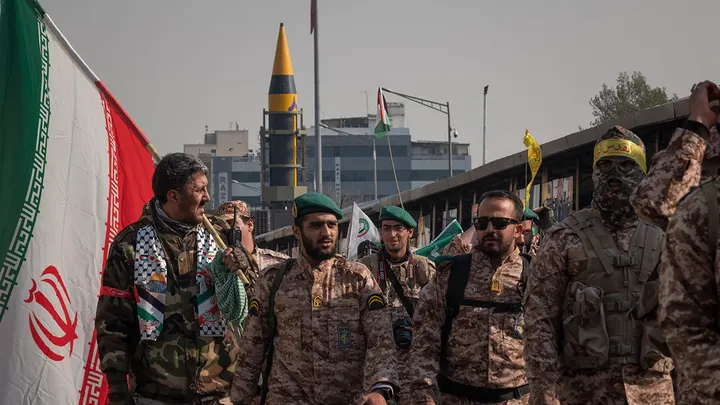 Islamic Revolutionary Guard Corps military personnel are walking along Enghelab (Revolution) Ave. as an Iranian Kheibar surface-to-surface missile is being unveiled during a military rally in Tehran, Iran, Nov. 24, 2023. (Morteza Nikoubazl/NurPhoto via Getty Images)