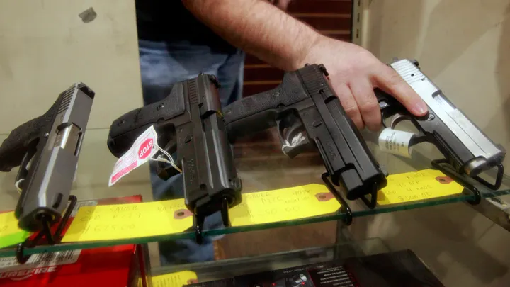 Todd Settergren handles pistols inside his display case at Setterarms gun shop in Walnut Creek, Calif., on Jan. 13, 2017. (Michael Macor/The San Francisco Chronicle via Getty Images)
