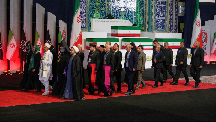 Iranian religious leaders and other mourners walk past the coffins of slain Iranian Supreme Leader Ayatollah Ali Khamenei and members of his family during a viewing ceremony ahead of the dayslong funeral ceremonies at the Imam Khomeini Mosalla Grand Mosque in Tehran, Iran, July 3, 2026.  (AP Photo/Vahid Salemi)