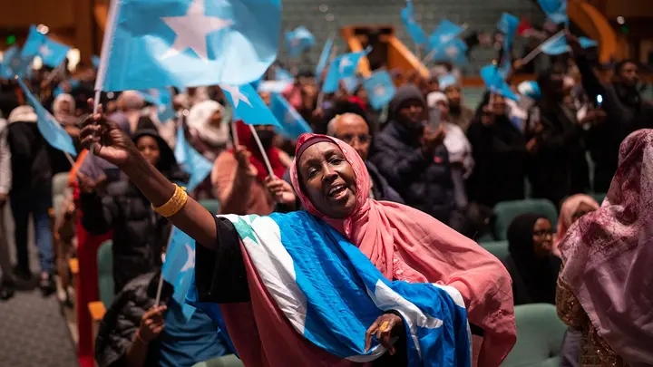 Attendees wave the Somali flag on Dec. 15, 2022, in the auditorium of the Minneapolis Convention Center awaiting the arrival of Somali President Hassan Sheikh Mohamud on Dec. 15, 2022. (Jeff Wheeler/Star Tribune via Getty Images)