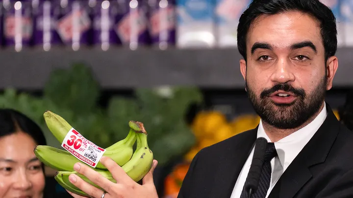 Zohran Mamdani, mayor of New York, holds up bananas labeled with a 30% off sticker during an announcement of municipal grocery stores at a Campaign for Hunger community food distribution center in the Brooklyn borough of New York, on Monday, July 27, (Adam Gray/Bloomberg via Getty Images)